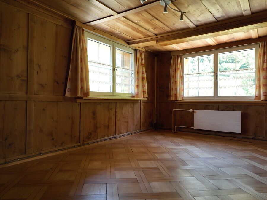 Leeres Zimmer mit Fischgratparkett und Holztäfer